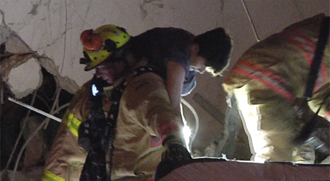 آتش نشانان یک بازمانده را از زیر آوار Champlain Towers South Condo نجات می دهند