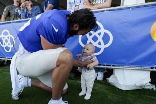 Rams tight end Colby Parkinson holds his son, Forrest, at training camp.