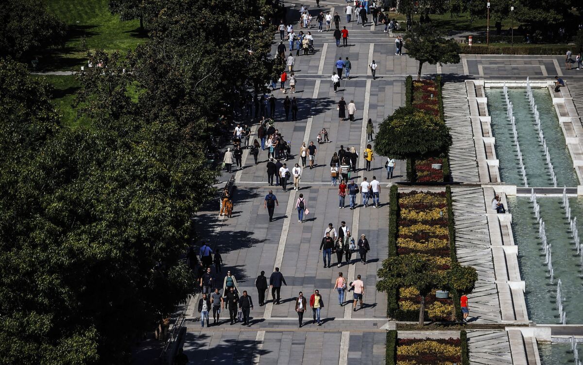 People walk in central part of Sofia, Sunday, Sept. 25, 2022. Bulgarians will go to the polls for the fourth time in less than two years in a general election overshadowed this time by the war in Ukraine, by rising energy costs and a galloping inflation. (AP Photo/Valentina Petrova)