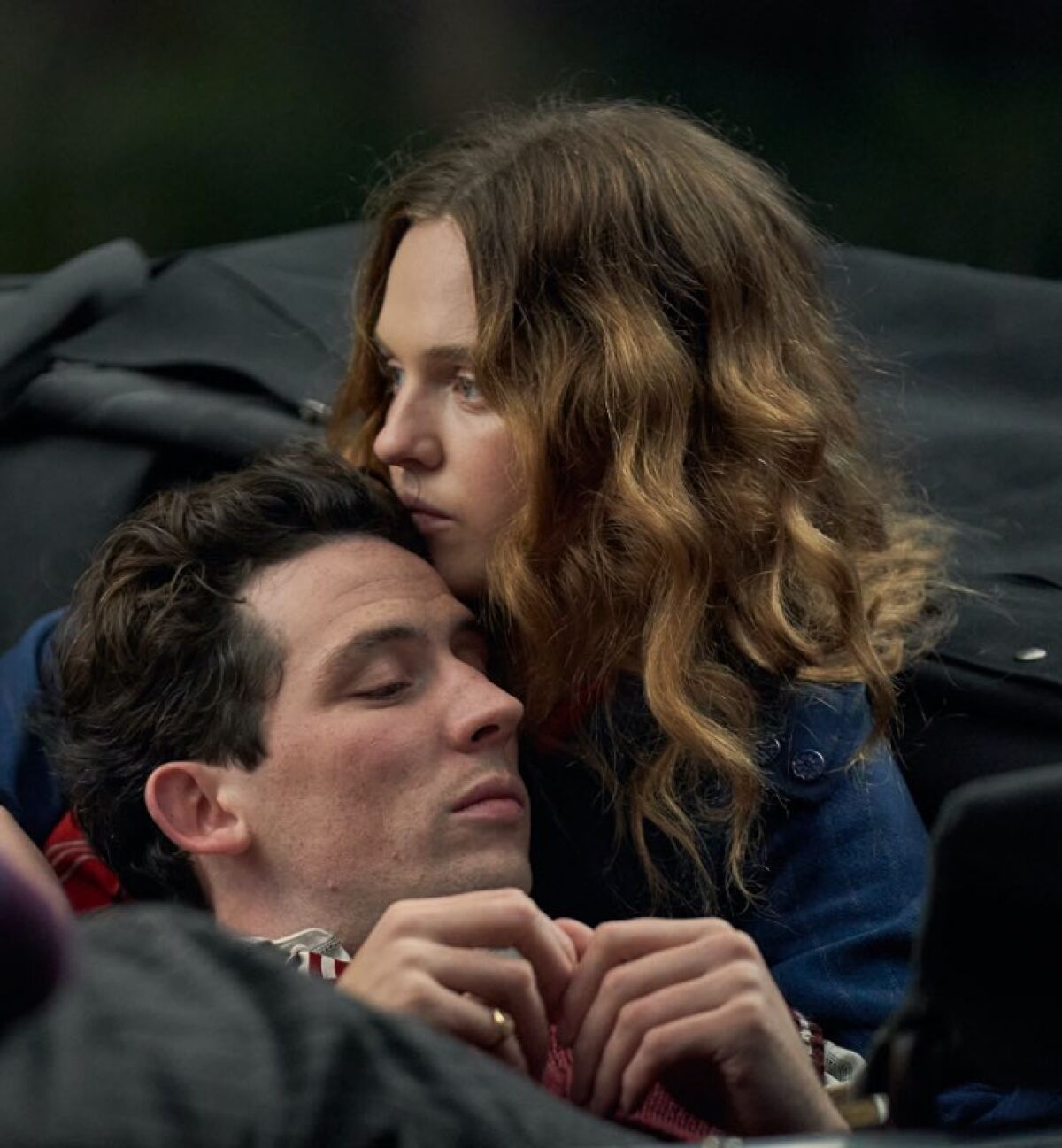 A man leans his head against a woman's shoulder.