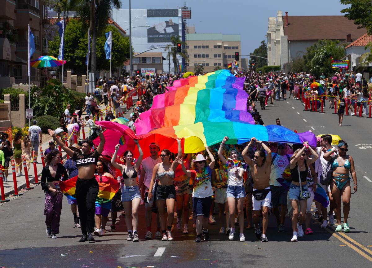 At Pride Parade in San Diego, participants carry the large Pride flag down Sixth Avenue toward Balboa Park 