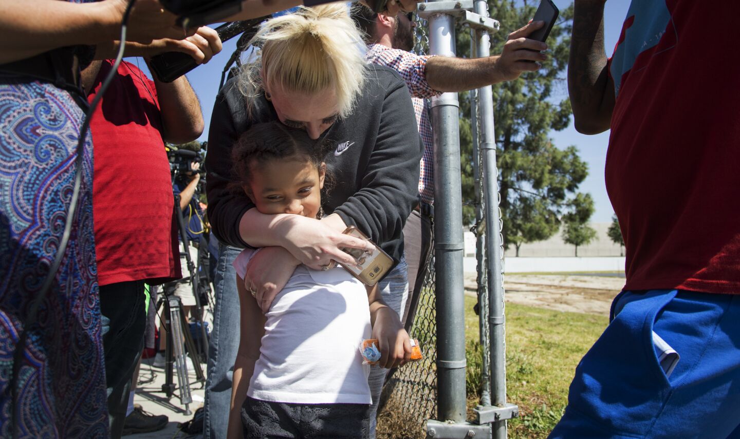Summer Terrell hugs her daughter Jaylah James, 5, after being reunited with her at Cajon High School hours after a shooting inside North Park Elementary School in San Bernardino.