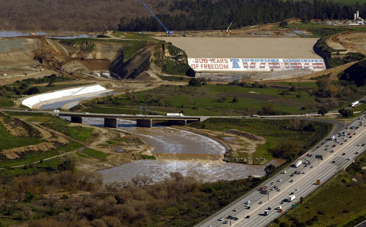 The bicentennial mural painted on the Prado Dam spillway in Corona, shown here in 2005, greets motorists entering Riverside County at the intersection of the 91 and 71 freeways. Residents of the area are fighting a plan to remove it.