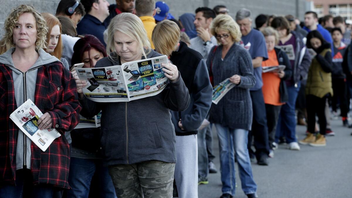People wait in line for a Best Buy store to open for a holiday sale last year, in Overland Park, Kan.