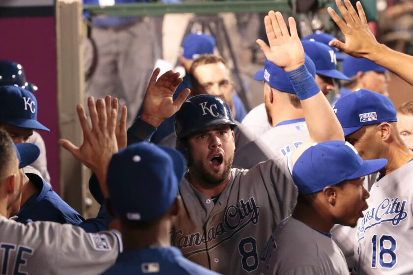 Royals third baseman Mike Moustakas celebrates with teammates after scoring against the Angels in the third inning.