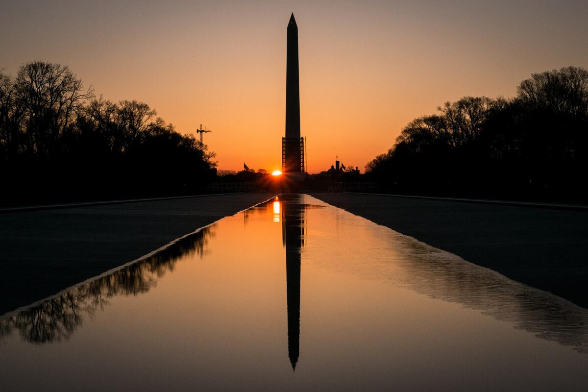 The sun peeks through the scaffolding around the Washington Monument. The National Park Service has announced it will reopen the earthquake-damaged structure in May.