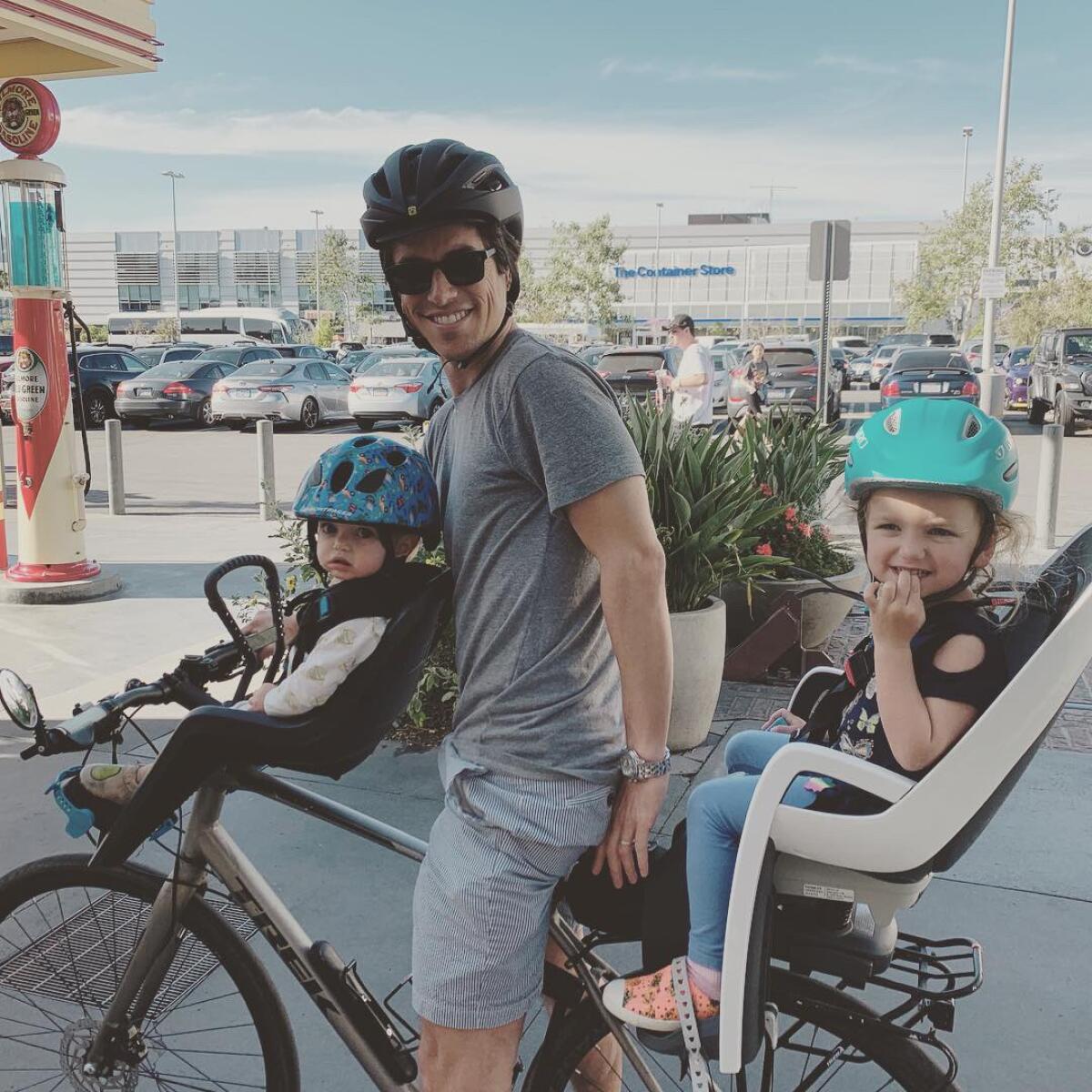 Michael Schneider with two of his three kids on a bike.