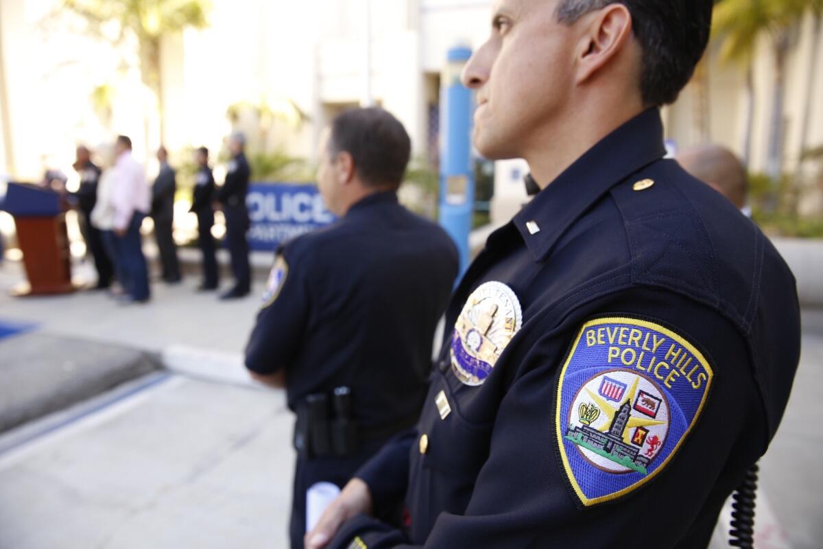 Beverly Hills police Lt Renato Moreno, right, watches a news conference addressing the sports cars racing in Beverly Hills and one driver's claim of diplomatic immunity.