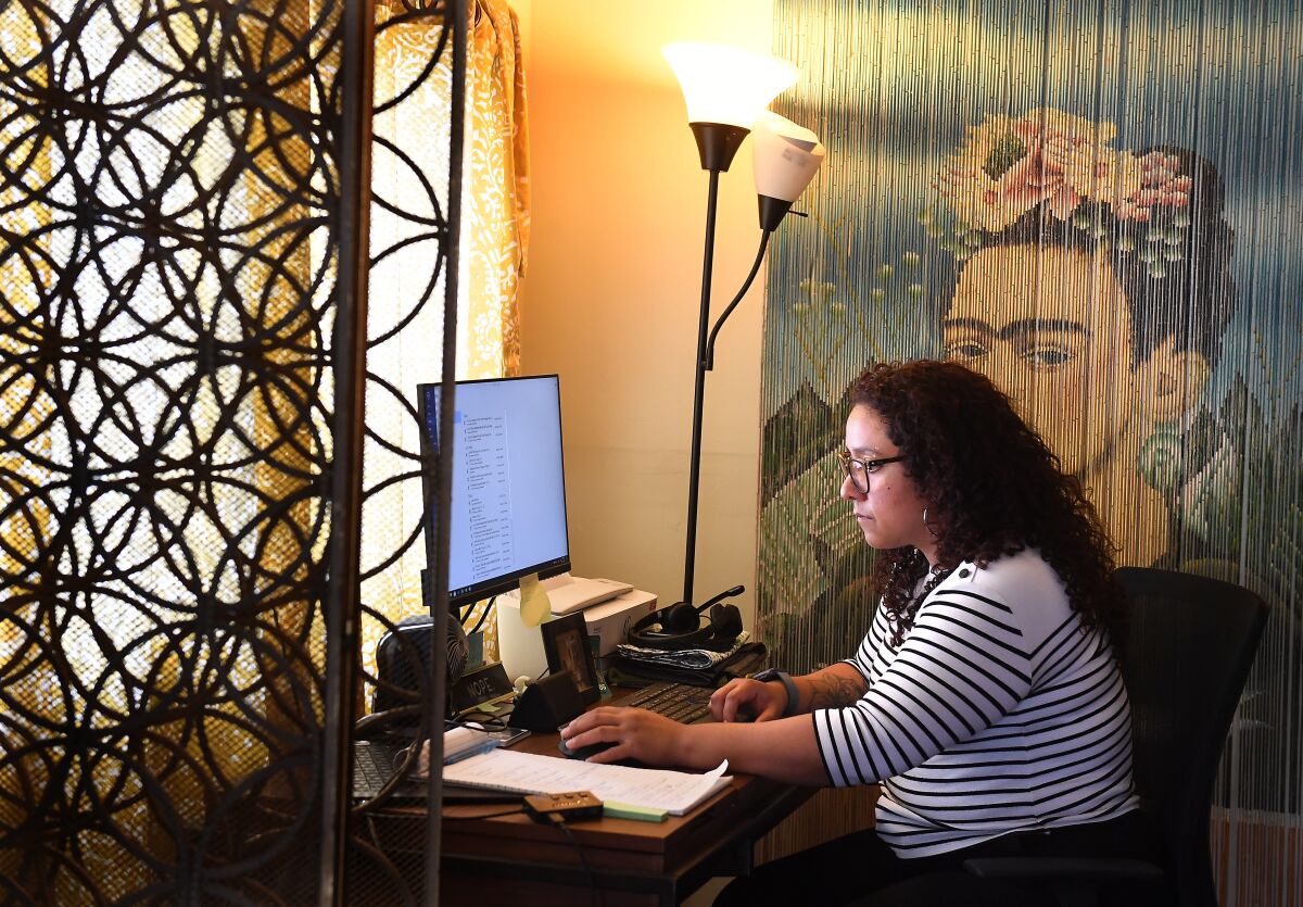 Jackie Cornejo sits in her home office in Los Angeles, where she makes vaccination appointments for her extended family.