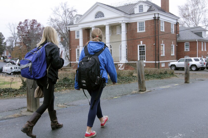 Students walk past the Phi Kappa Psi fraternity house on the University of Virginia campus in Charlottesville, Va.