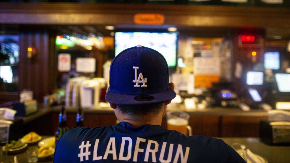 A Dodgers fan sits at the bar at OB Bear in Koreatown to watch Game 1 of the National League Division Series against the Atlanta Braves on Oct. 4, 2018.