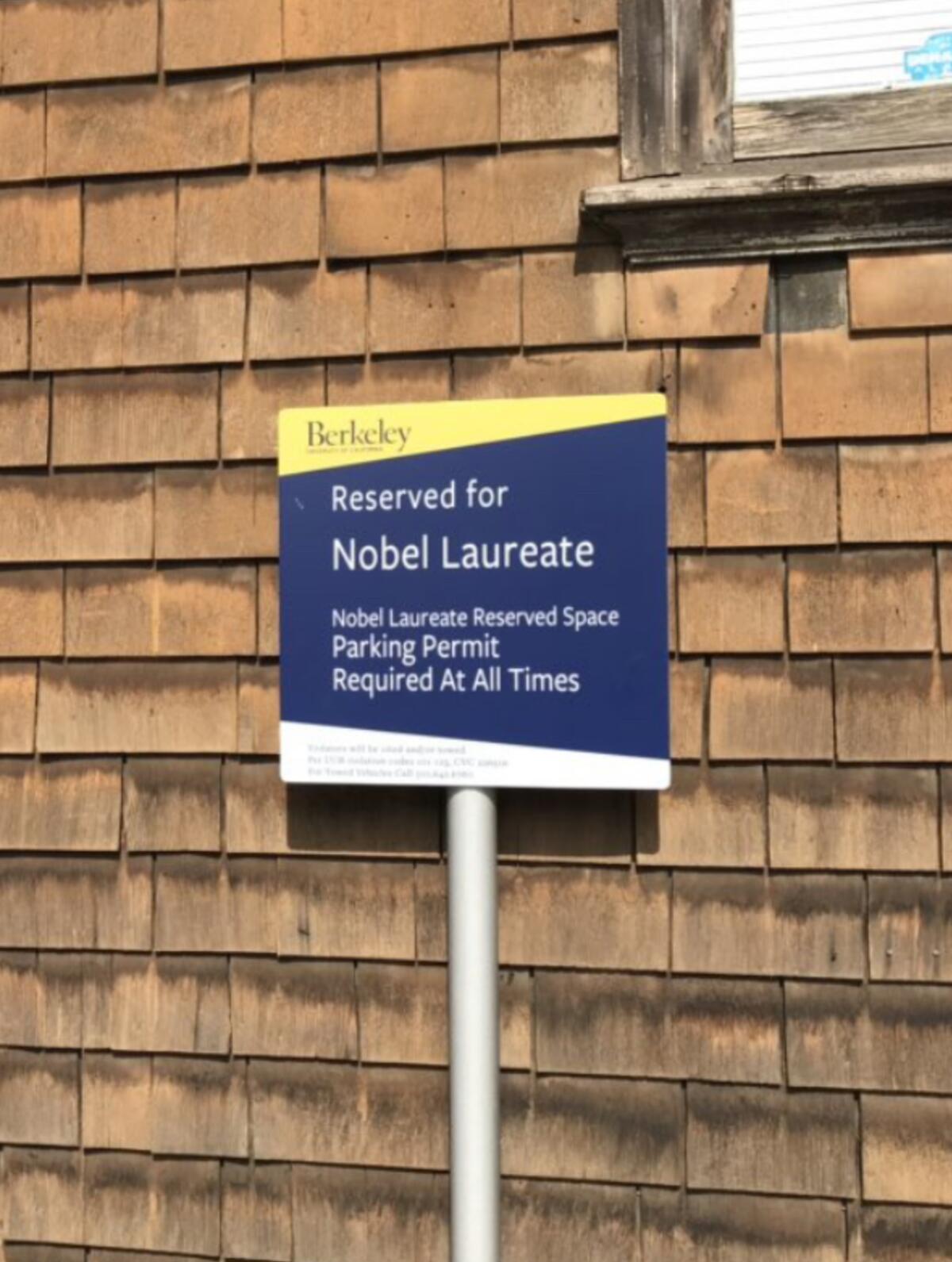 A sign against shingled siding reads "Reserved for Nobel laureate."