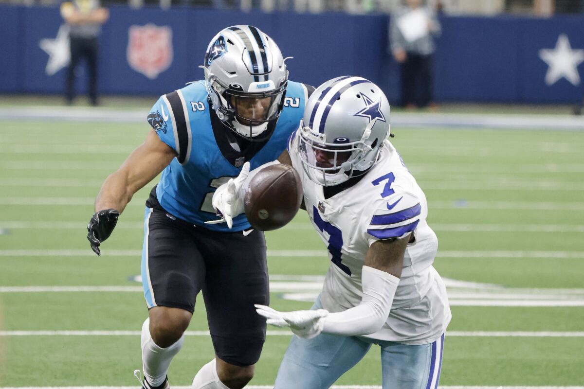 Dallas Cowboys cornerback Trevon Diggs (7) intercepts a pass intended for Carolina Panthers wide receiver DJ Moore (2) in the second half of an NFL football game in Arlington, Texas, Sunday, Oct. 3, 2021. (AP Photo/Michael Ainsworth)