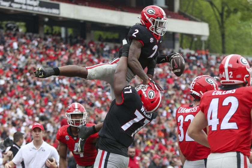 Georgia running back Kendall Milton (2) celebrates after a touchdown with offensive lineman Devin Willock (77) in the first half of Georgia's spring NCAA college football game, Saturday, April 16, 2022, in Athens, Ga. (AP Photo/Brett Davis)