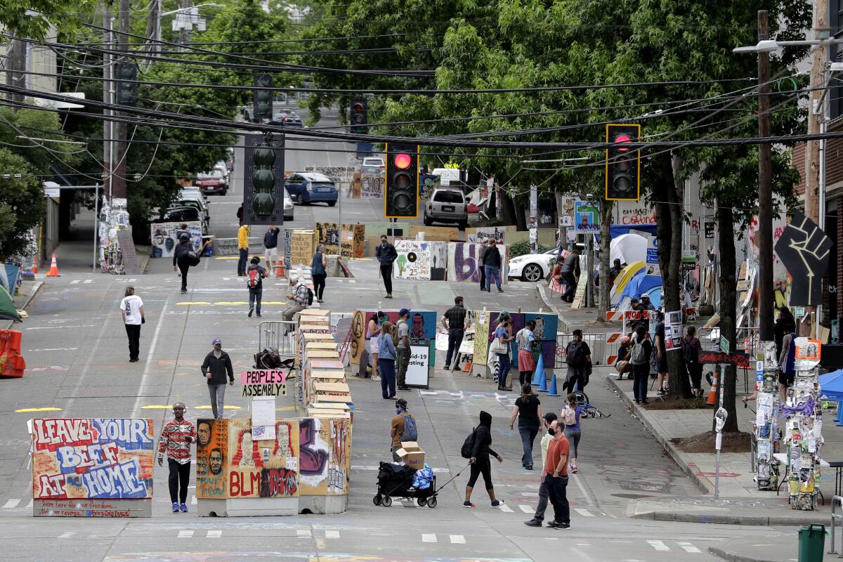 Occupiers, residents and visitors walk by barricades Wednesday in Seattle's Capitol Hill Occupied Protest zone.