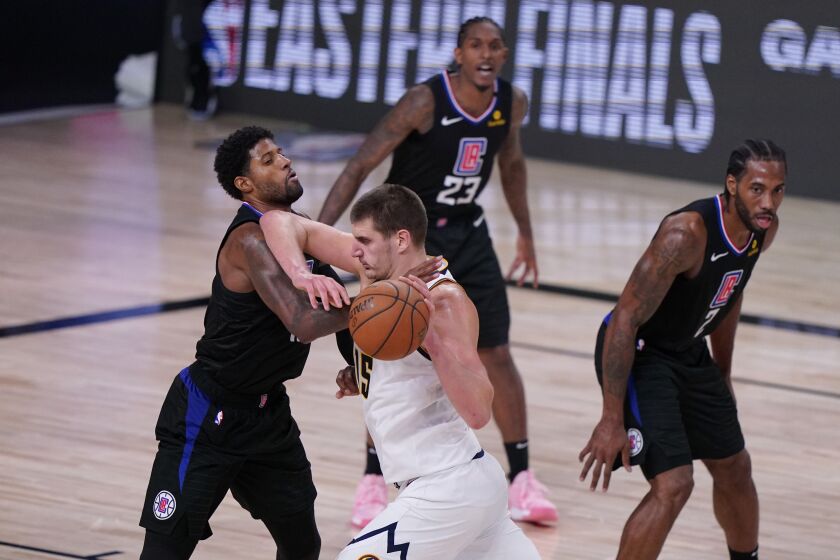 Denver Nuggets center Nikola Jokic (15) drives against Los Angeles Clippers guard Paul George (13) during the second half of an NBA conference semifinal playoff basketball game Tuesday, Sept. 15, 2020, in Lake Buena Vista, Fla. (AP Photo/Mark J. Terrill)