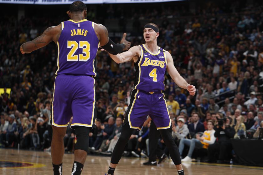 Lakers forward LeBron James congratulates guard Alex Caruso (4) after he scored late in the second half against the Nuggets in a game Feb. 12, 2020, in Denver.