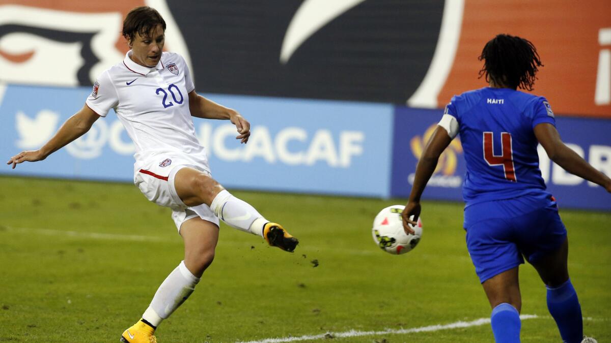 U.S. forward Abby Wambach, left, scores past Haiti defender Kencia Marseille during the second half of a 6-0 victory in group play at the CONCACAF championship on Monday.