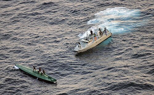 Mexican navy sailors ride on top of a seized drug smuggling submarine as it was being towed by a navy ship off the coast of the Pacific resort city of Huatulco, Mexico.