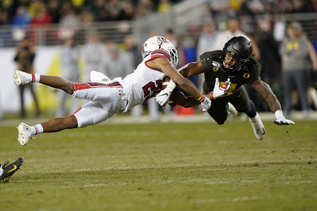 FILE - In this Dec. 6, 2018, file photo, Oregon safety Jevon Holland (8) breaks up a pass for Utah wide receiver Jaylen Dixon (25) during the first half of the Pac-12 Conference championship NCAA college football game in Santa Clara, Calif. A group of Pac-12 football players on Sunday, Aug. 2, 2020, threatened to opt out of the coming season unless its concerns about competing during the COVID-19 pandemic and other racial and economic issues in college sports are addressed. (AP Photo/Tony Avelar, File)