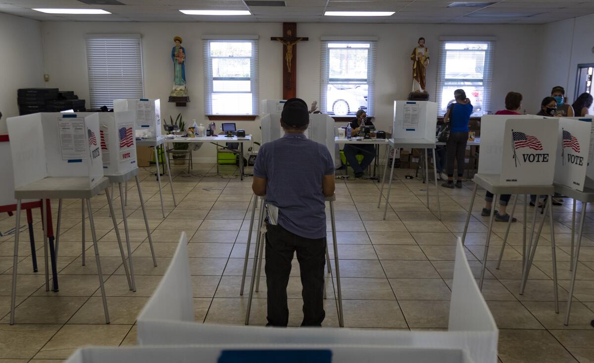 A voter stands at a polling place in a church.