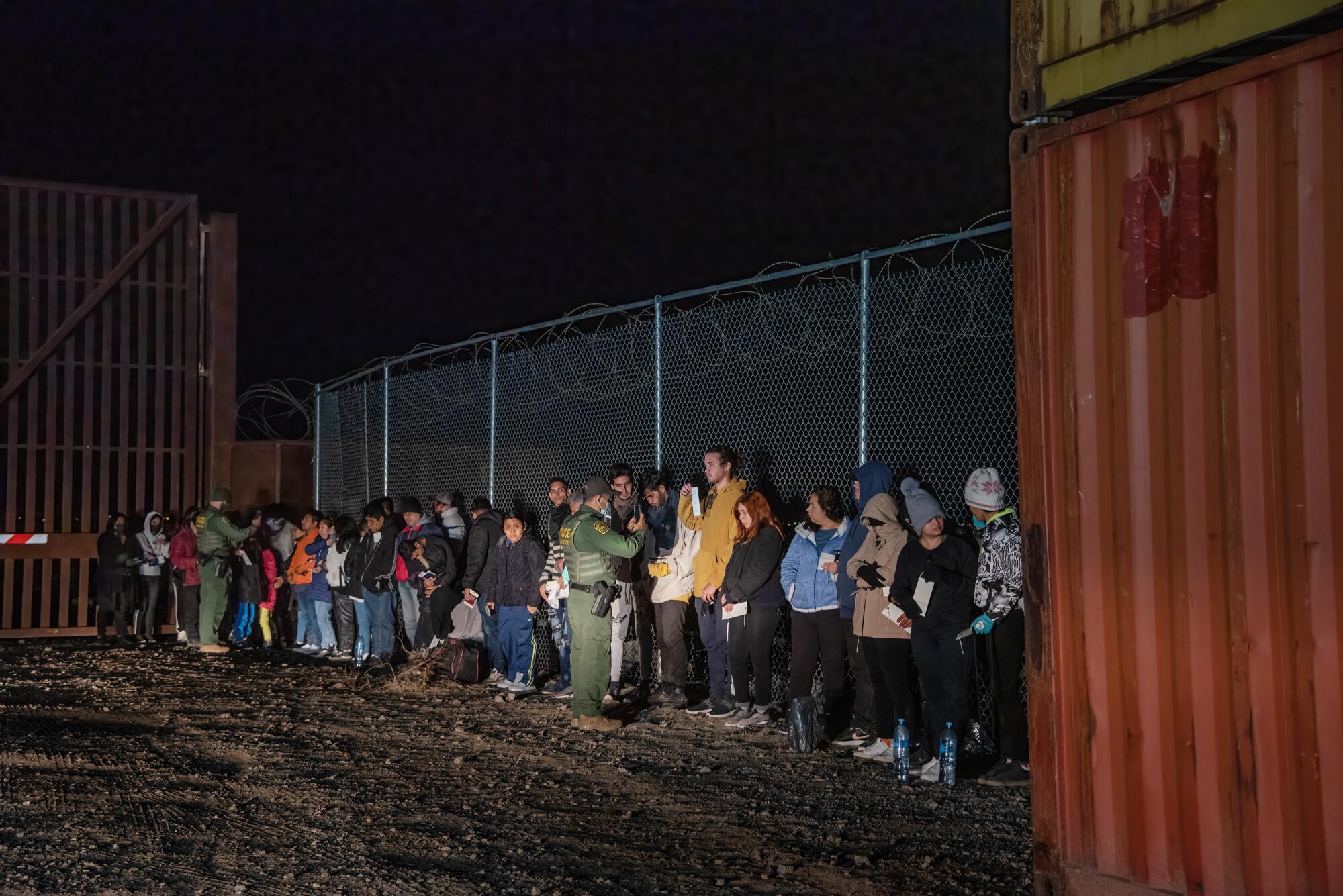 Two U.S. Border Patrol agents photograph part of about 100 people who surrendered after crossing the Mexico/Arizona border