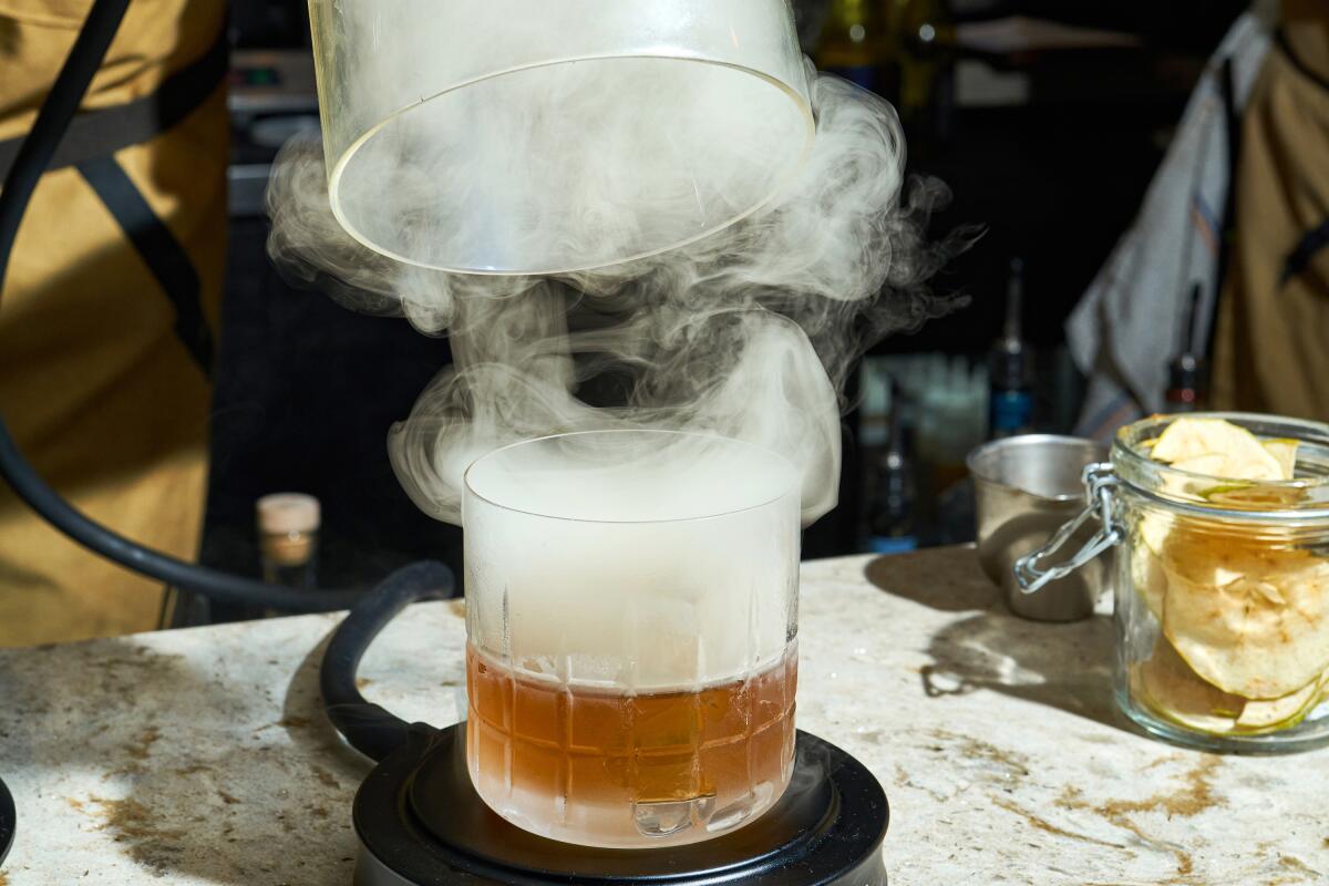 The Apples to Oranges cocktail, which involves terpenes, is shown after it’s smoked using applewood chips and a gravity bong.