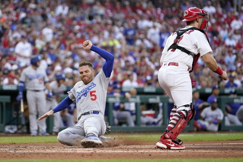 Los Angeles Dodgers' Freddie Freeman (5) scores past St. Louis Cardinals catcher Andrew Knizner during the fourth inning of a baseball game Thursday, July 14, 2022, in St. Louis. (AP Photo/Jeff Roberson)