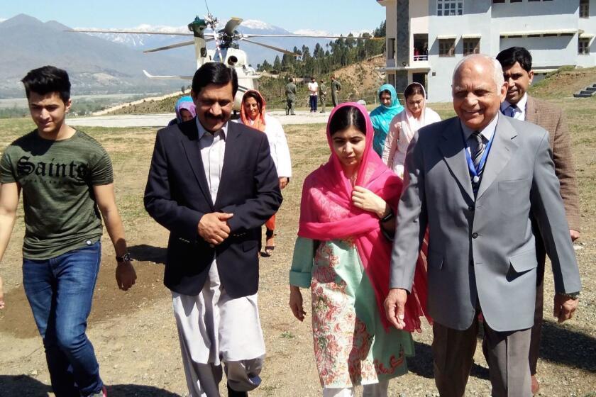 Pakistani activist and Nobel Peace Prize laureate Malala Yousafzai (C), arrives along with her father Ziauddin Yousafzai (2L), brother Atal Yousafzai (L) and the principal of all-boys Swat Cadet College Guli Bagh, during her hometown visit, some 15 kilometres outside of Mingora, on March 31, 2018. Malala Yousafzai landed in the Swat valley on March 31 for her first visit back to the once militant-infested Pakistani region where she was shot in the head by the Taliban more than five years ago. / AFP PHOTO / ABDUL MAJEEDABDUL MAJEED/AFP/Getty Images ** OUTS - ELSENT, FPG, CM - OUTS * NM, PH, VA if sourced by CT, LA or MoD **