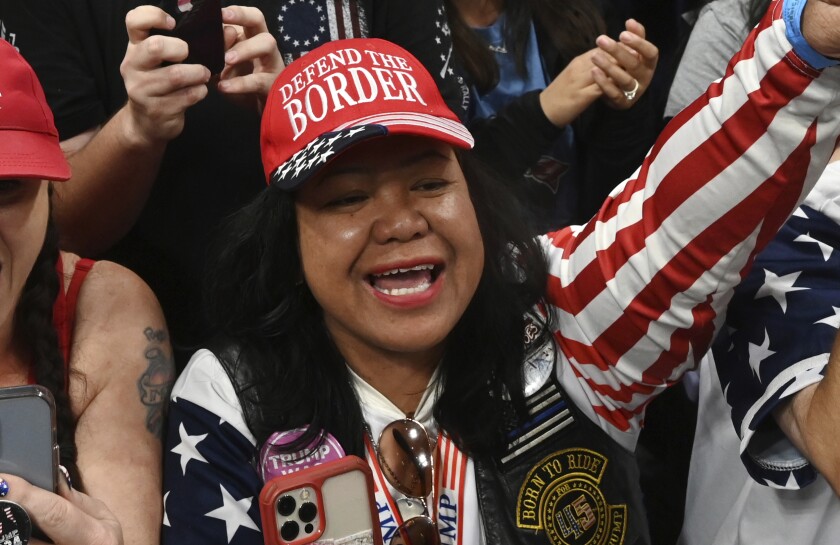 Mimi Israelah, center, cheers for Donald Trump inside the Alaska Airlines Center in Anchorage, Alaska, during a rally Saturday July 9, 2022. An investigation has been launched after a person believed to be an Anchorage, Alaska, police officer was shown in a photo with Israelah flashing a novelty “White Privilege card.” The social media post caused concerns about racial equality in Alaska’s largest city. (Bill Roth/Anchorage Daily News via AP)
