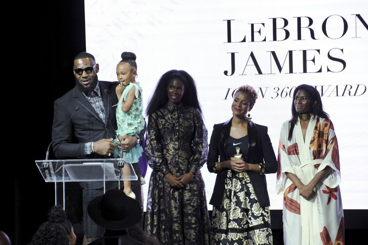 Lakers star LeBron James holds his daughter Zhuri as he accepts the Harlem Fashion Row's ICON 360 Award on Sept. 4.