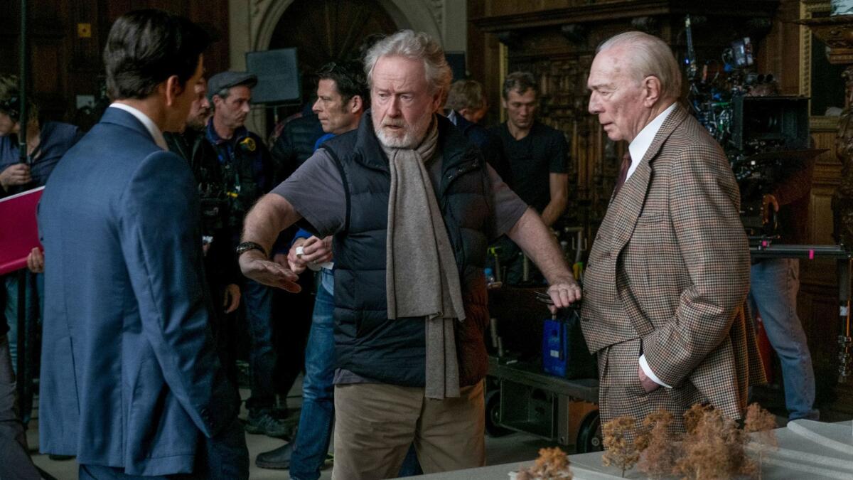 Mark Wahlberg, left, and Christopher Plummer, right, listening to Ridley Scott on the set of "All The Money In The World."