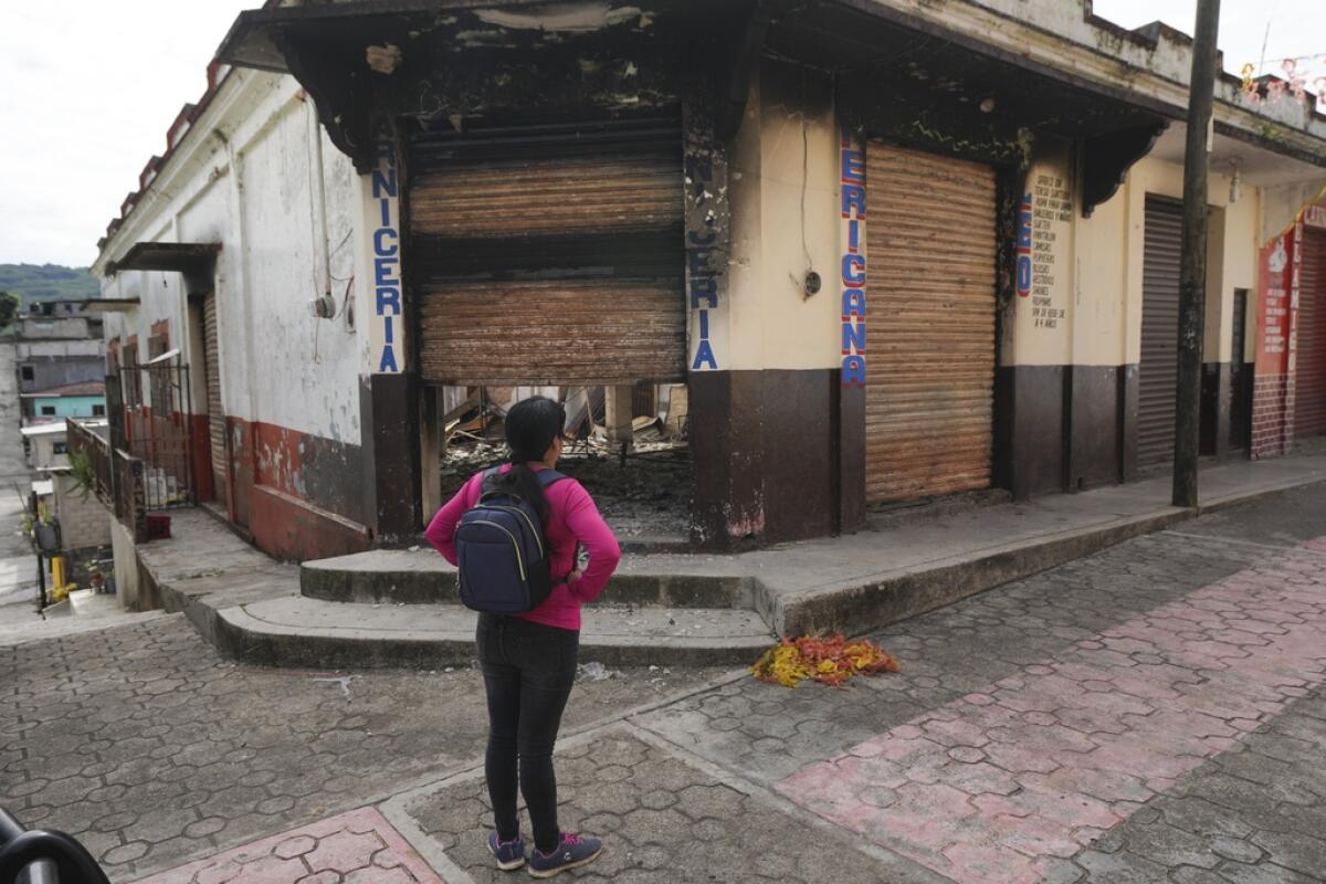 Una vecina observa los restos quemados de un edificio
