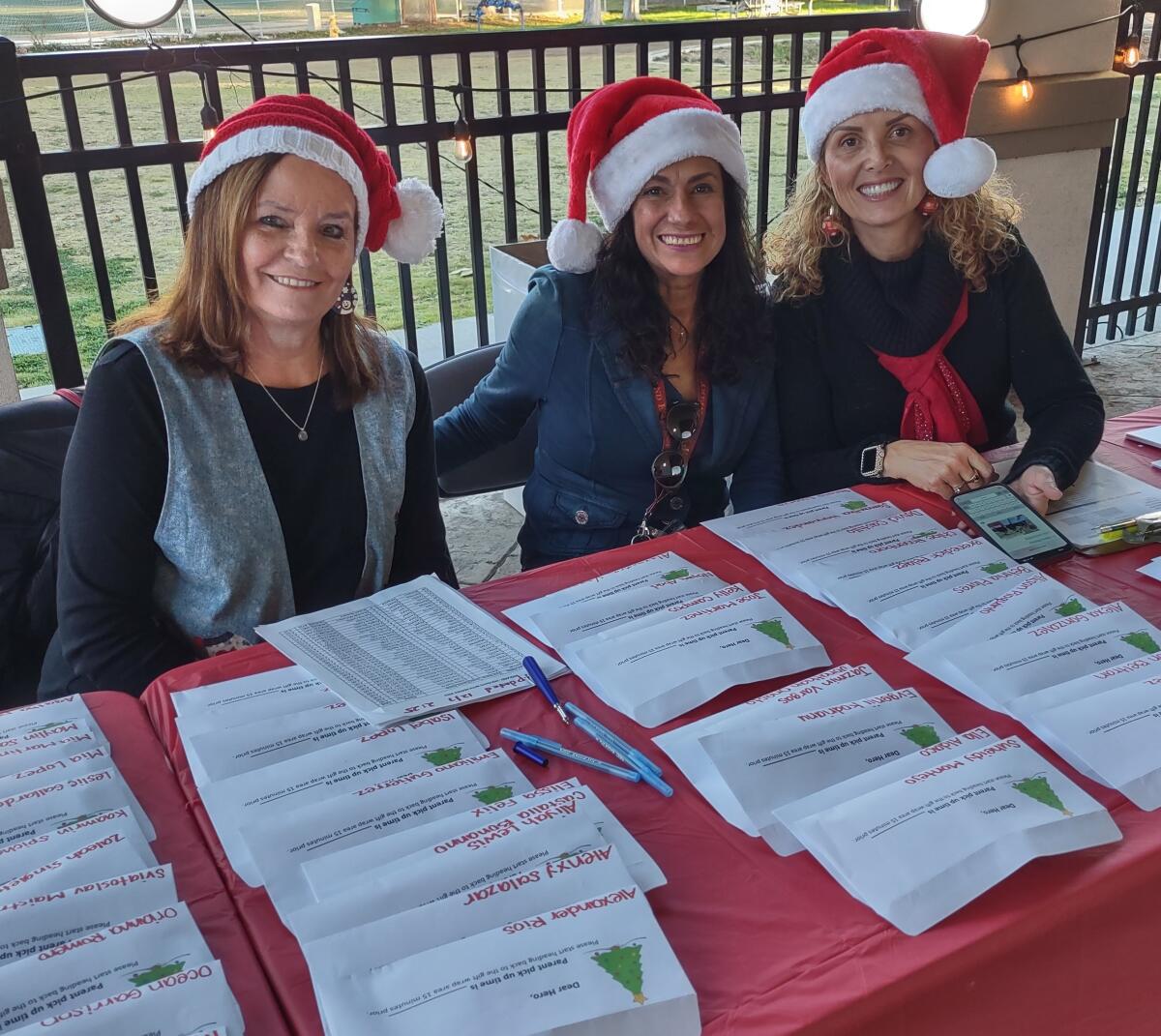 Volunteers who helped check-in children are, from left, Lidia Vandevelde, Marly Ramos and Lella Dalessandro.