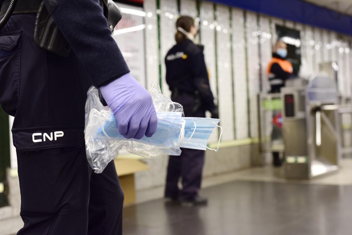 Police officers distribute face masks among the Metro passengers on April 14, 2020 in Madrid, Spain. Spain is beginning to ease strict lockdown measures to ease its economy, people in some services including manufacturing, construction are being allowed to return to work.