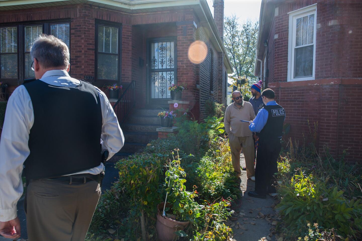 Chicago police officers talk Nov. 3, 2015, to neighbors along 80th Street and South Damen Avenue, where Tyshawn Lee, 9, was fatally shot the day before.