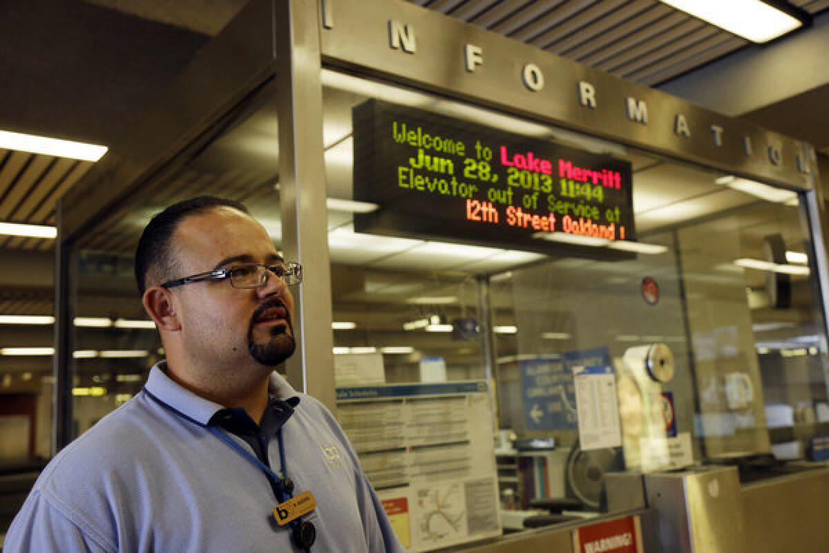 BART station agent Mark Madrigal stands next to his booth at the Lake Merritt station in Oakland.