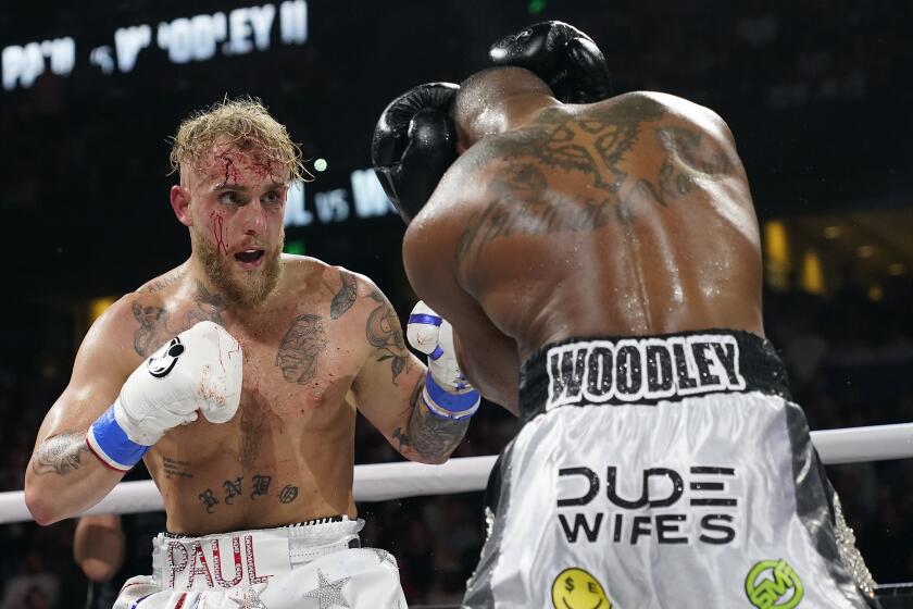 Jake Paul, left, punches Tyron Woodley during the second round of a Cruiserweight fight on Dec. 19, 2021
