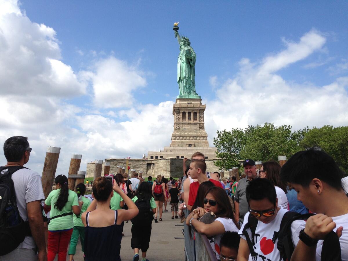 Tourists gather near the reopened Statue of Liberty in New York.