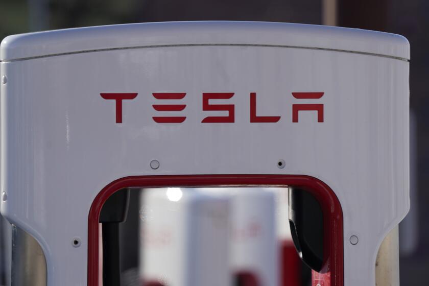 FILE - The company logo is shown at the top of a supercharger for Tesla automobiles near shops Feb. 25, 2021 in Boulder, Colo. Tesla's quarterly profit has surpassed $1 billion for the first time thanks to the electric car pioneer's ability to navigate through a pandemic-driven computer chip shortage that has caused major headaches for other automakers. The financial milestone announced Monday, July 26, 2021 extended a two-year run of prosperity that has erased questions about Tesla’s long-term viability raised during its early years of losses and production problems. (AP Photo/David Zalubowski, file)
