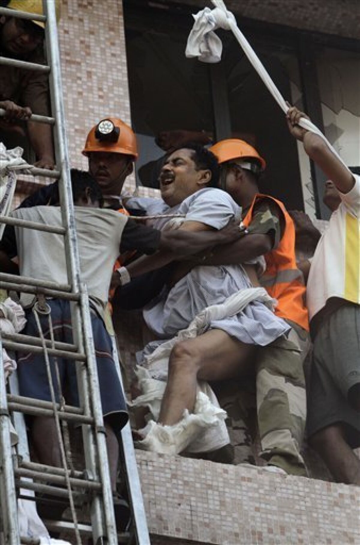 Fire officials rescue a patient as he cries in a pain, from the window of a nursing home after it caught fire in Kolkata, India, Friday, Dec. 9, 2011. A fire swept through a multistory nursing home in eastern India early Friday, trapping many elderly residents in the smoke-filled building, an official said. (AP Photo/Bikas Das)