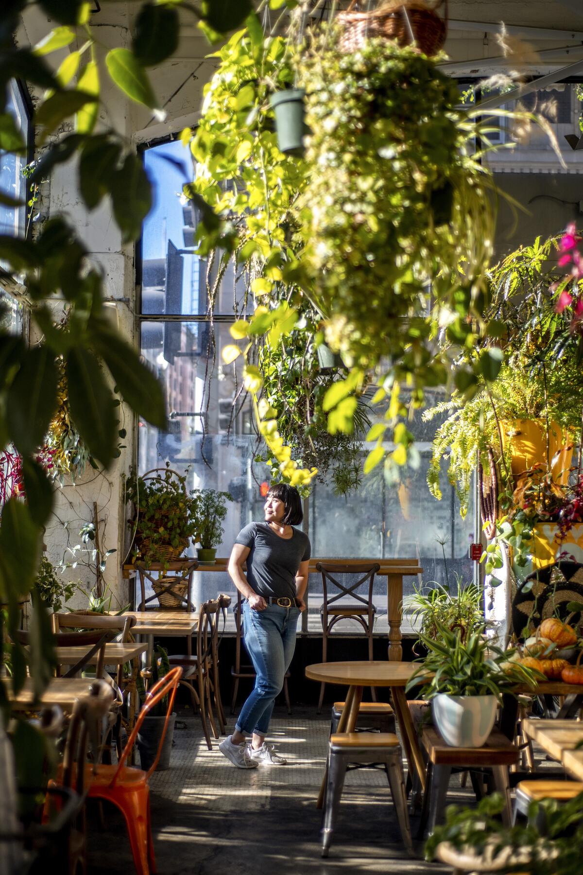 Yuko Watanabe inside one of her restaurants, surrounded by plants.