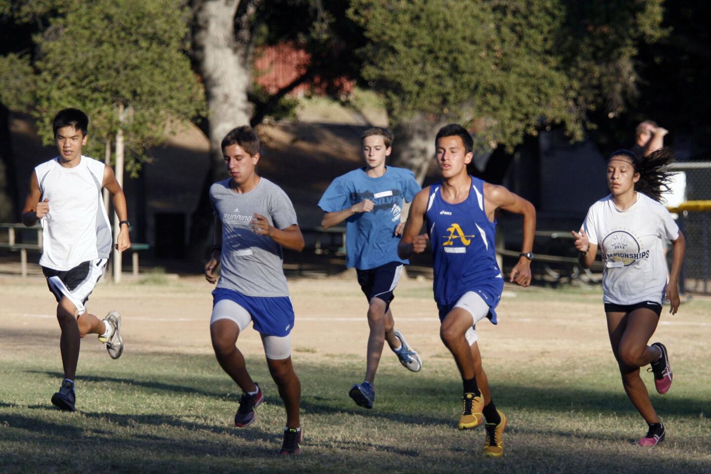 Runners sprint as they participate in a race series at Crescenta Valley Park on Wednesday, August 8, 2012.