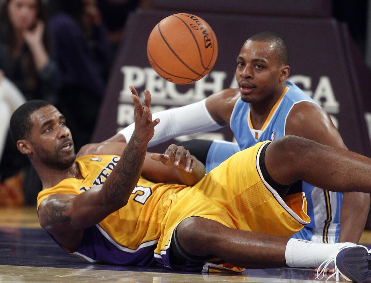 Lakers forward Shawne Williams passes the ball as Denver Nuggets guard Randy Foye looks for the steal.