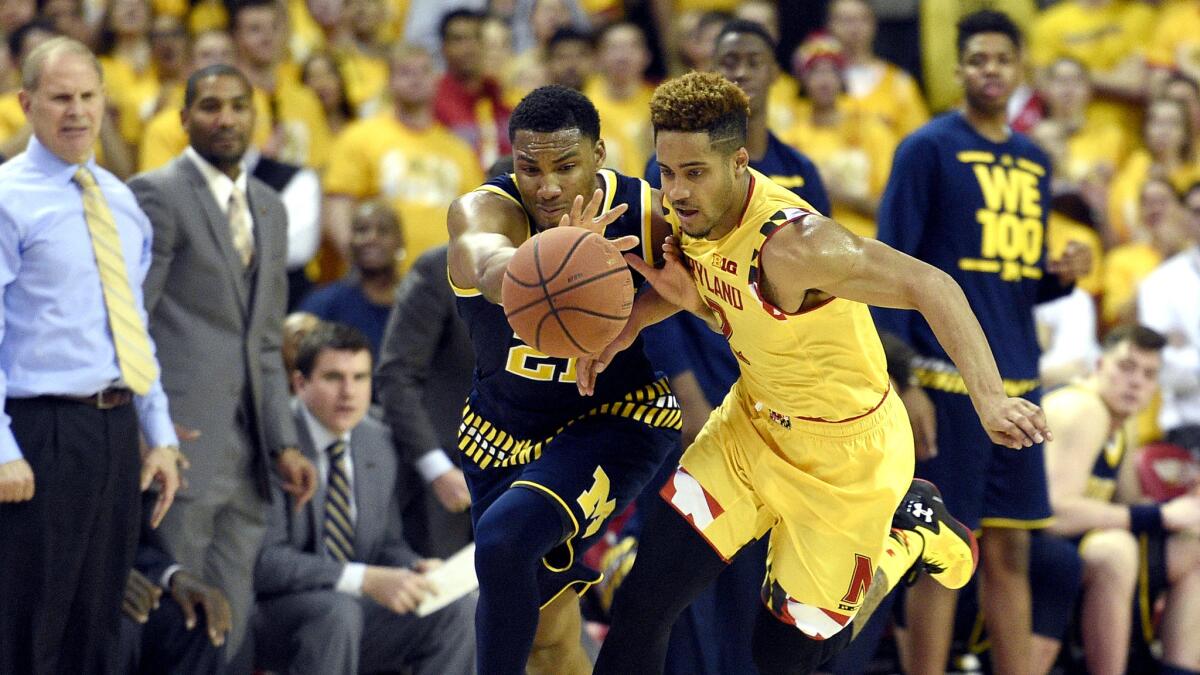 Michigan guard Zak Irvin, left, and Maryland guard Melo Trimble chase after a loose ball during the second half Sunday.