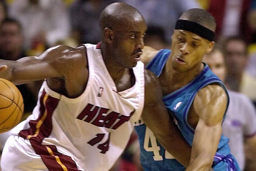 Miami Heat forward Anthony Mason, left, tries to drive past Charlotte Hornets center P.J. Brown during a game in April 2001.