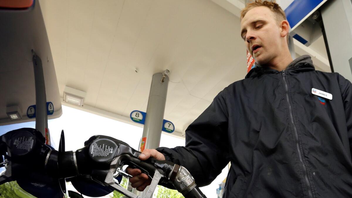 Gas-station attendant James Lewis pumps gas in Portland, Ore., in 2015.