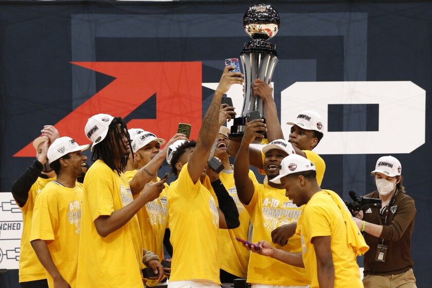 St. Bonaventure players raise the trophy after beating VCU.