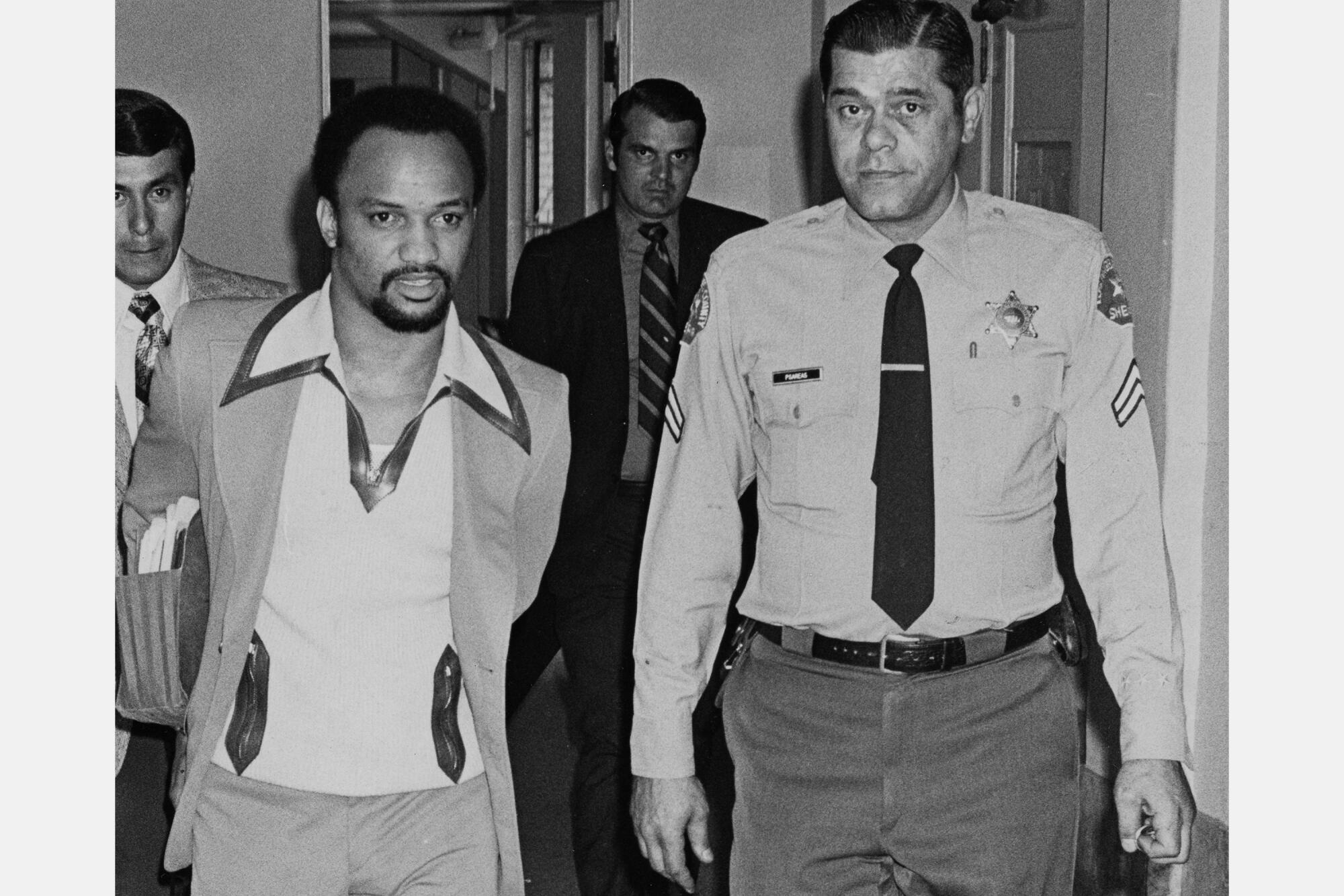 Elmer Pratt being escorted to a court session