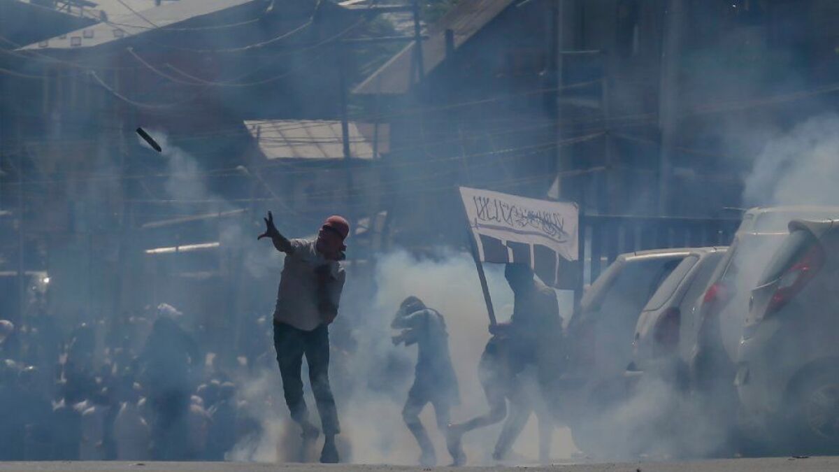 A protester throws a tear gas shell back at Indian police in Srinagar, the capital of Indian-controlled Kashmir, on June 2, 2018.